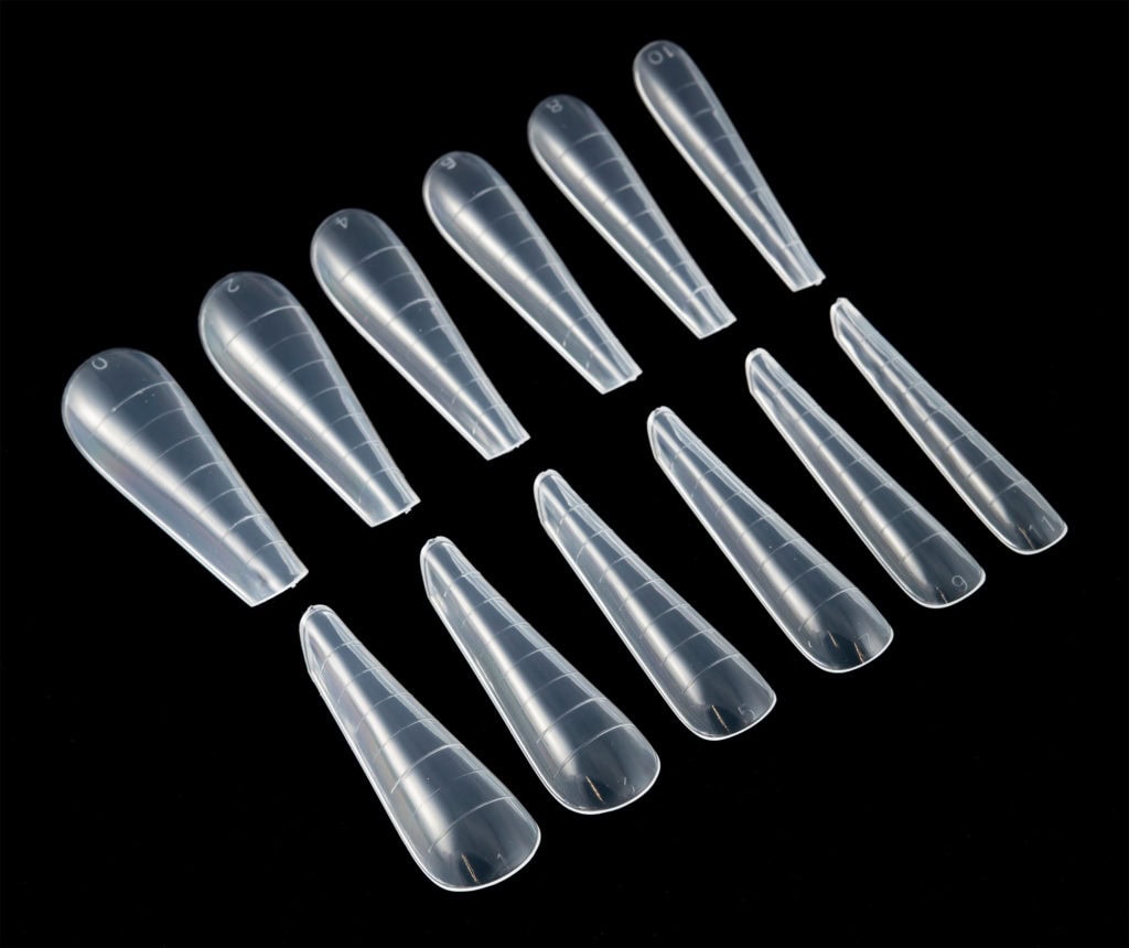 Transparent acrylic nail tips arranged in a neat row for professional manicures and nail enhancements in Northern Ireland.